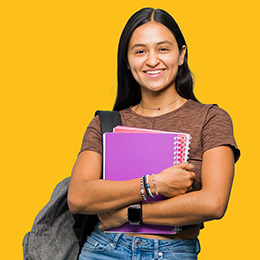 A happy woman holding note books.