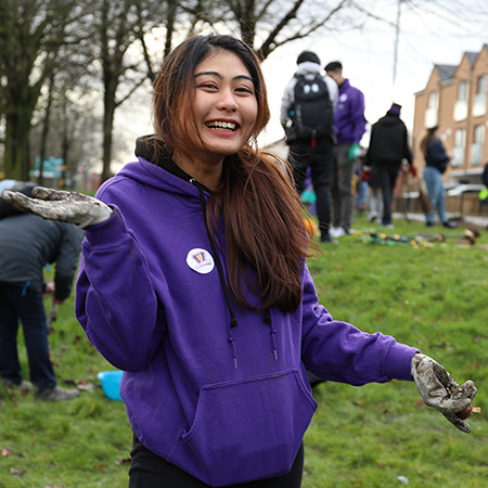 Happy student completing volunteering in a local green.