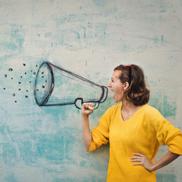 Woman speaking confidently with a megaphone.