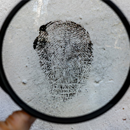 Magnifying glass looking at a fingerprint. 