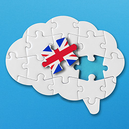 Puzzle of a brain, with one piece taken out with the English flag, representing the English language.