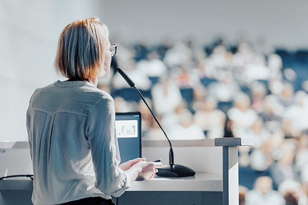 A woman completing a lecture to students.