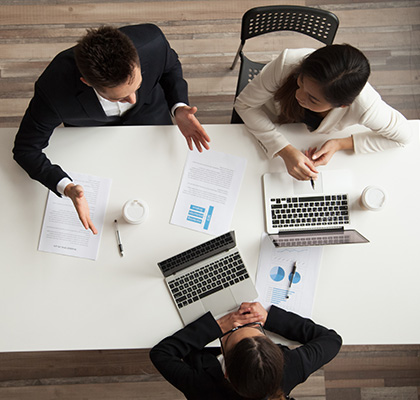 Three individuals around a table for a job interview.