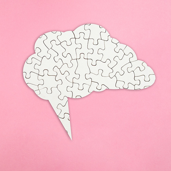 Speech bubble puzzle in the shape of a brain.